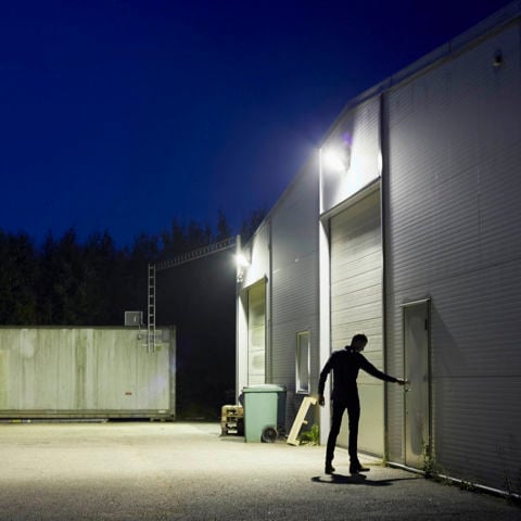person som i mörkret öppnar en dörr