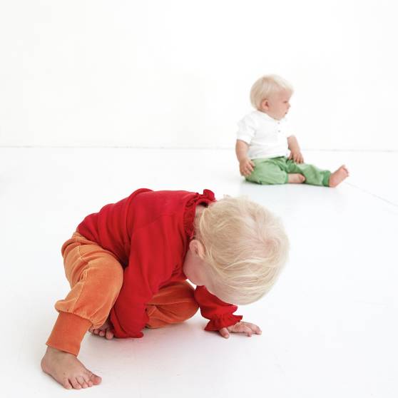 Två bebisar som sitter på golvet