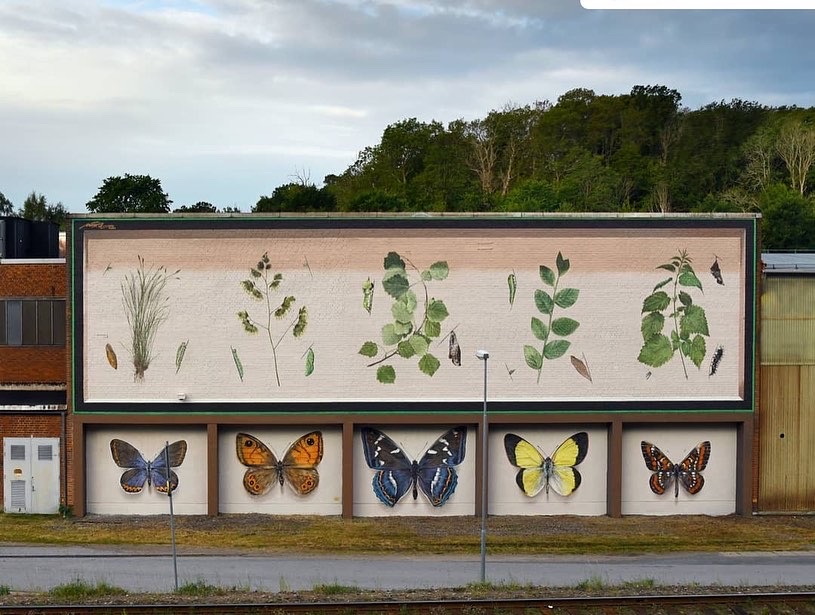 Väggmålning föreställande fjärilar och gröna växter. 