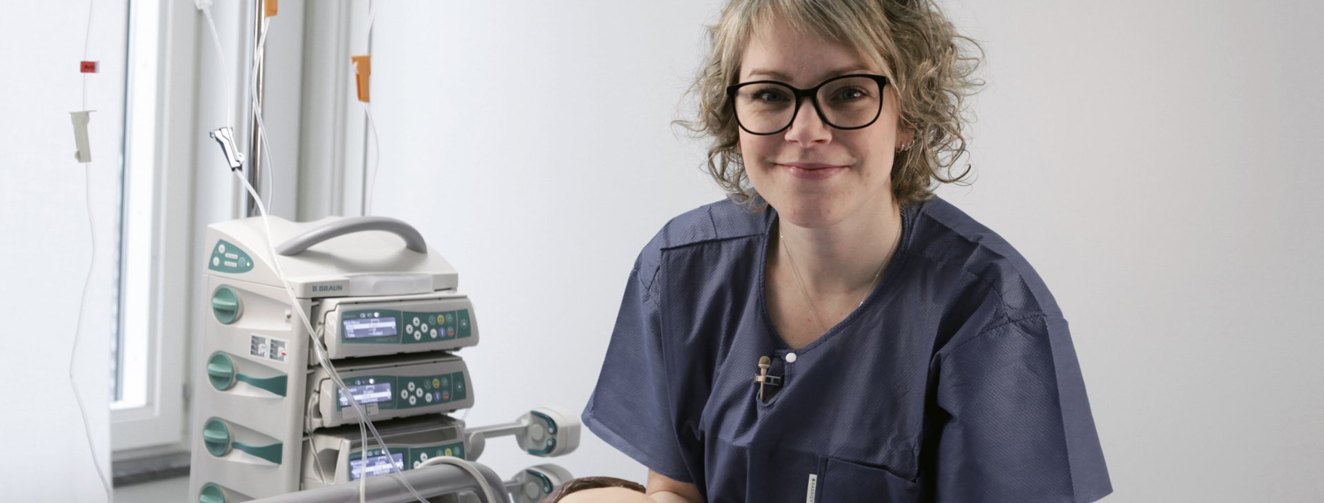 Bild på en sjuksköterska som arbetar på en träningsdocka i en klinisk miljö.