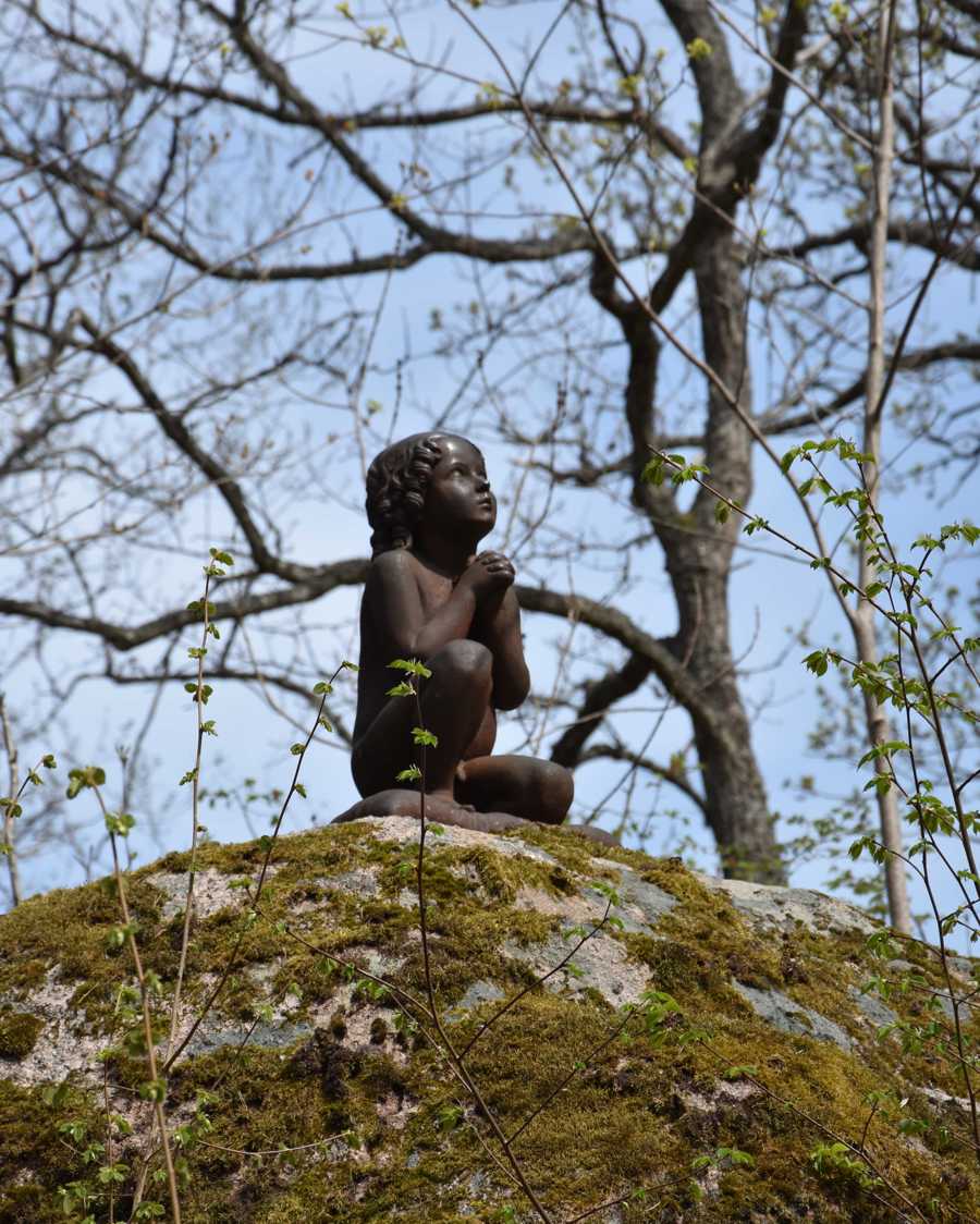 Staty föreställande en bedjande liten pojke.