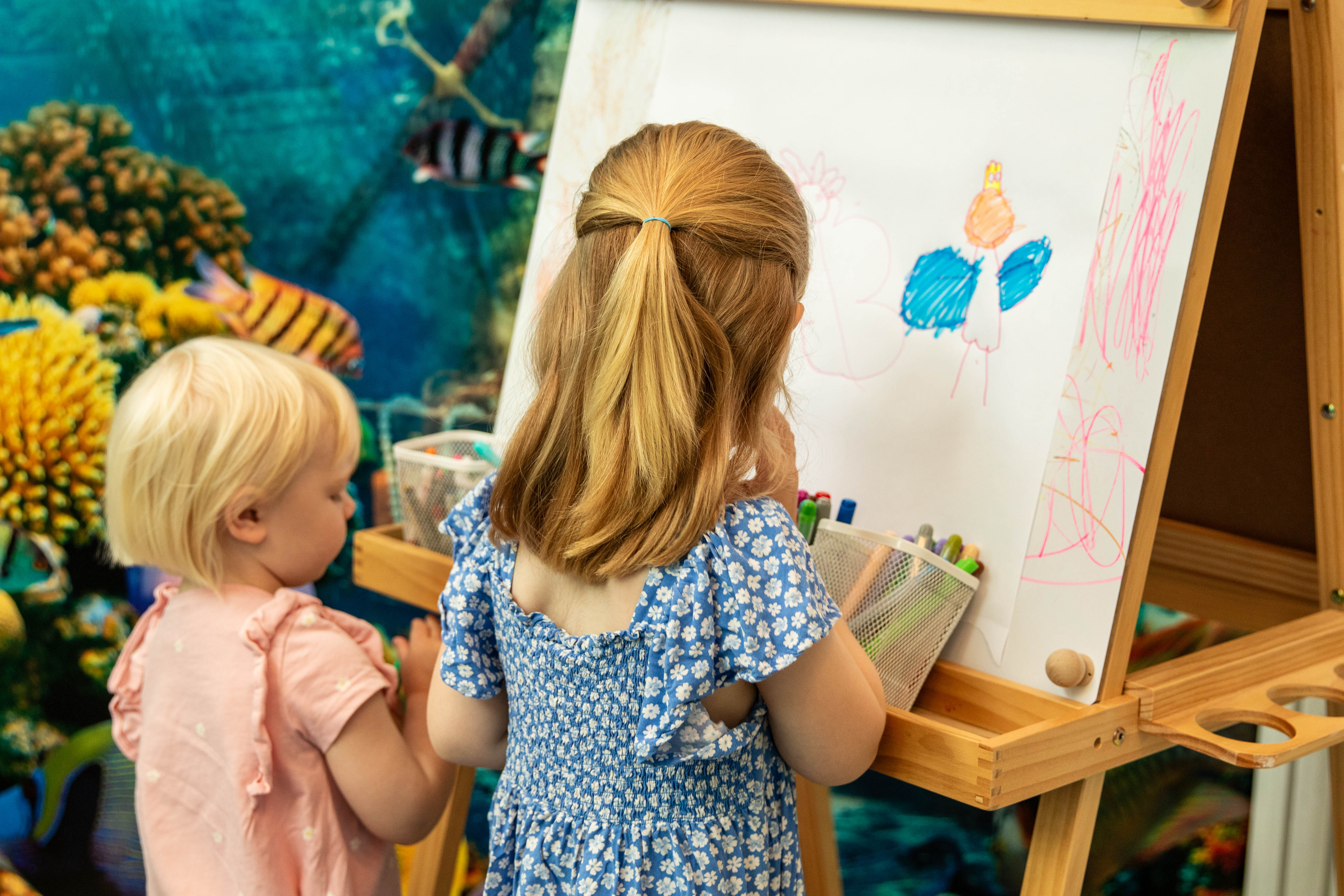 Barnen Alva och Wilma målar på tavla.