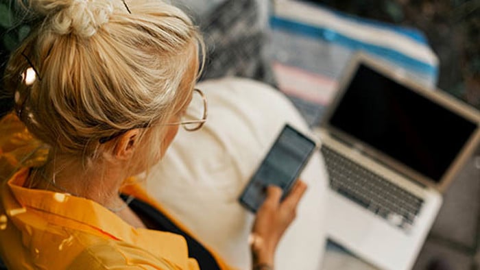 Person som sitter och tittar på en mobil.