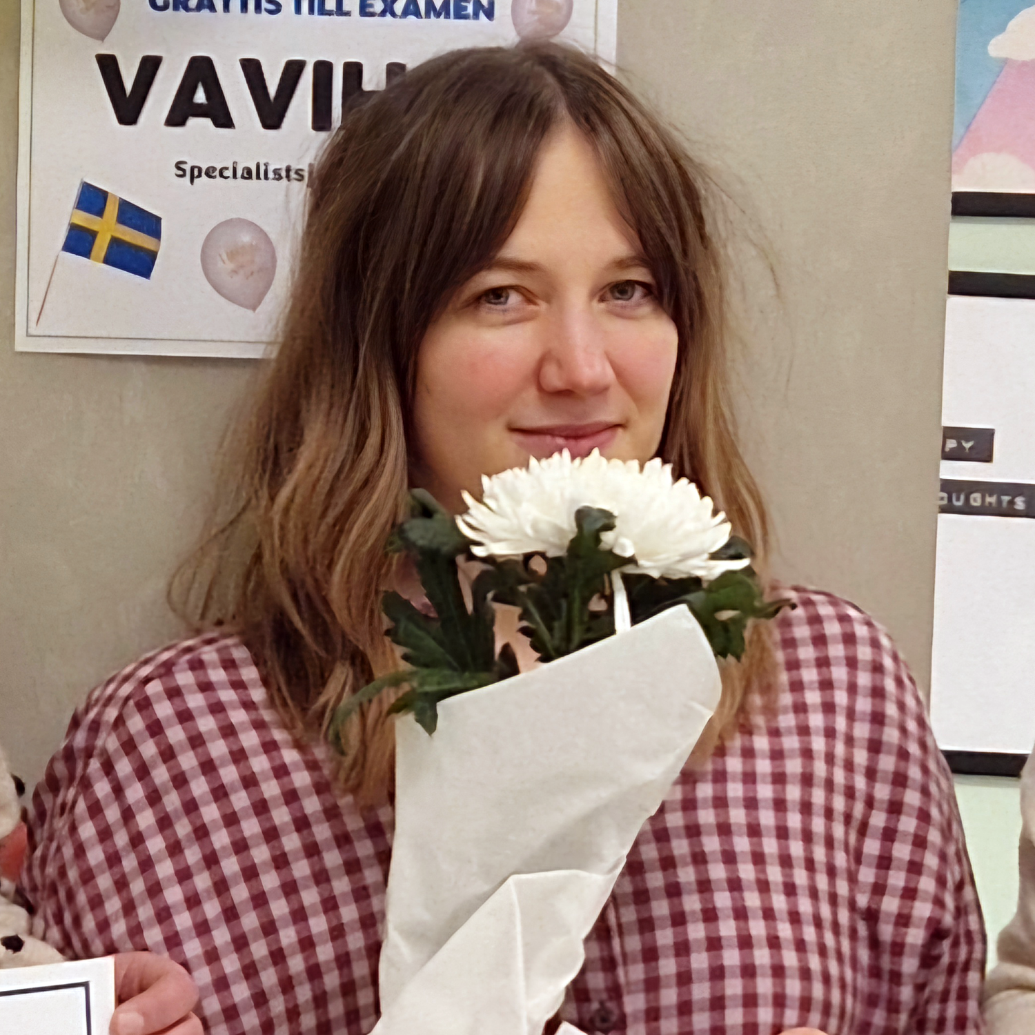 Bild på en student som håller i en vit blomma.