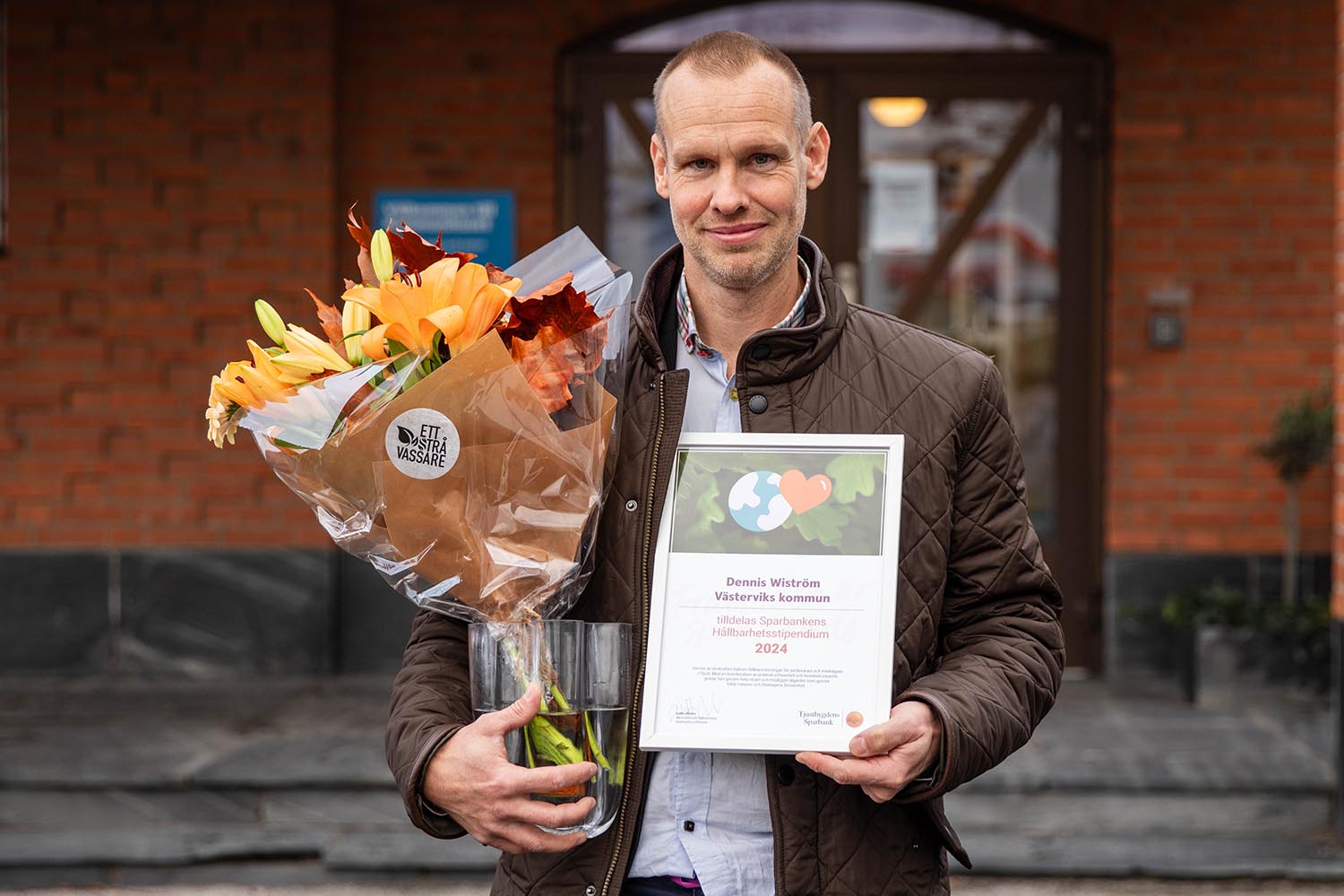 Samhällsbyggnadsenhetens Dennis Wiström med blommor och diplom efter stipendieutdelning