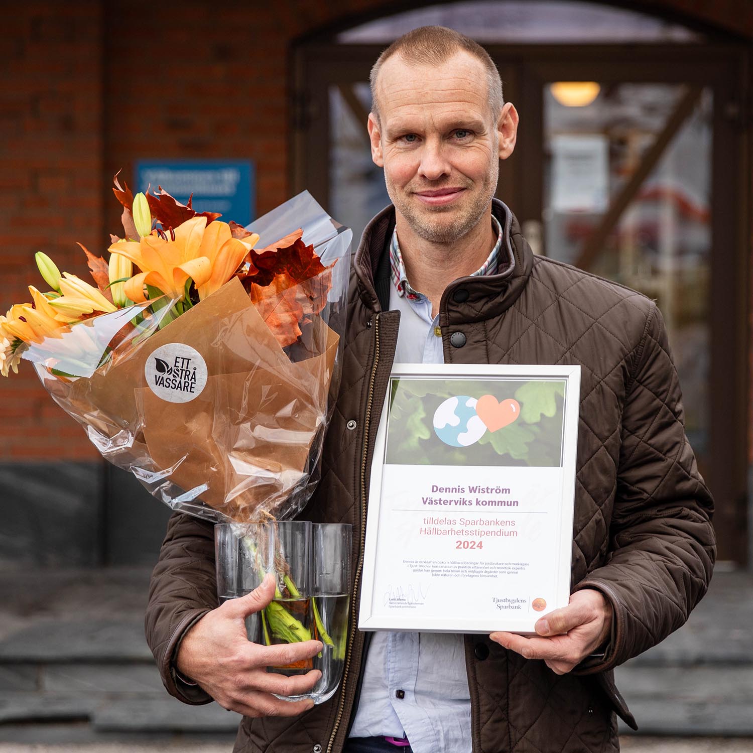 Samhällsbyggnadsenhetens Dennis Wiström med blommor och diplom efter stipendieutdelning