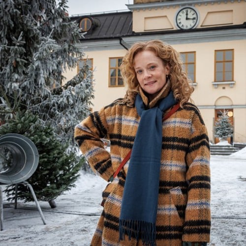 Skådespelaren mamma Moa syns bredvid en snöig julgran på Stora torget.