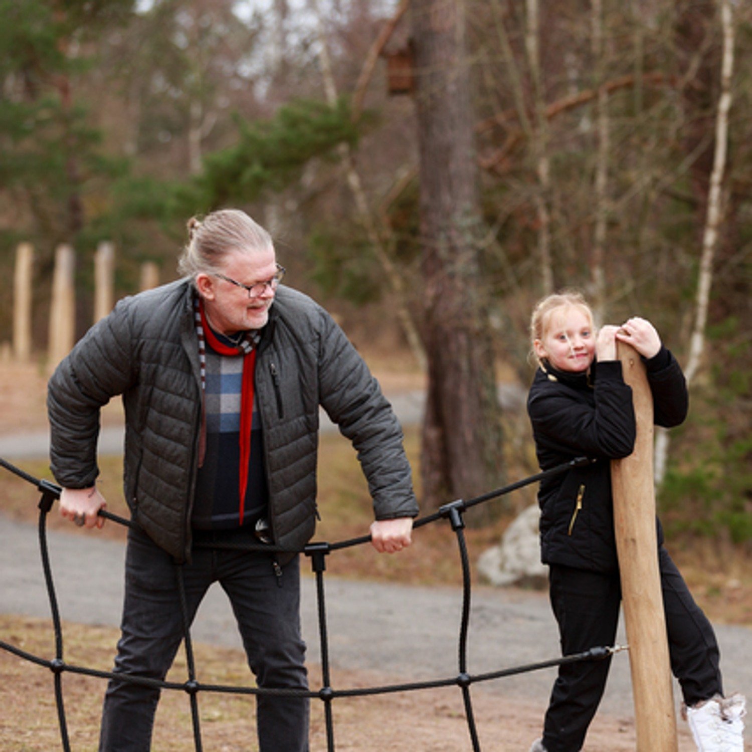 Morfar och barnbarn leker i hinderbana.