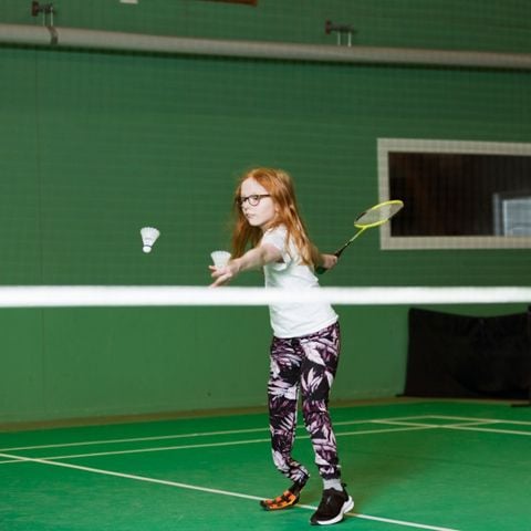 Flicka som spelar badminton.