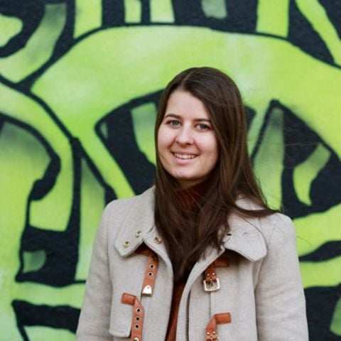 Ung kvinna framför en väggmålning.