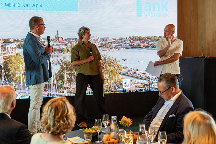 Konferenciärerna Sara Nordling och Niklas Lind på scenen tillsammans med kommunstyrelsens Harald Hjalmarsson.