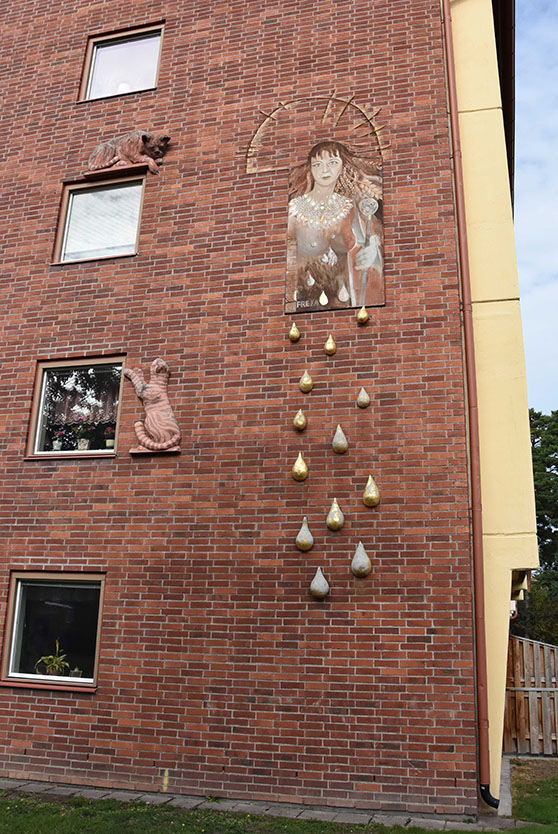 Konstverk med kvinna som gråter på husvägg