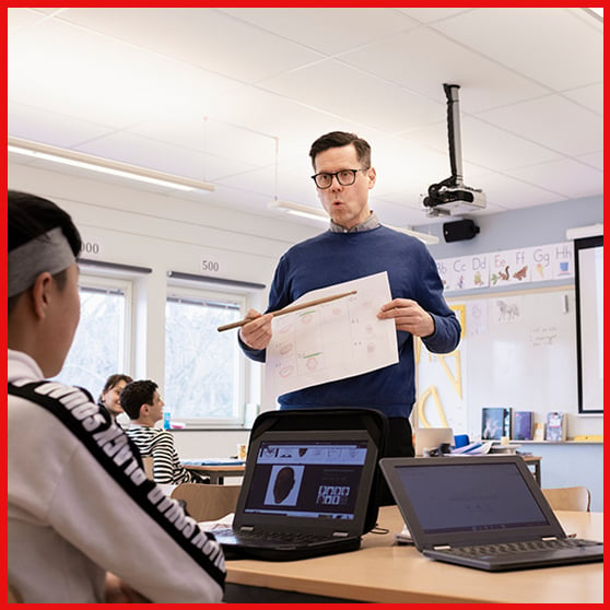 bild på lärare med elever i klassrum i röd ram
