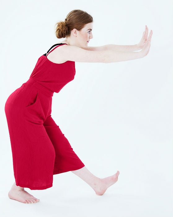 En kvinna i röd dräkt dansar